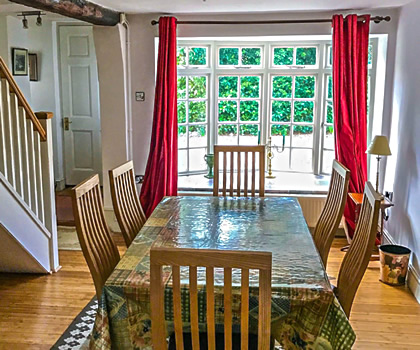 Interior photo of Church Cottage showing the dining room with French doors to the rear garden & patio